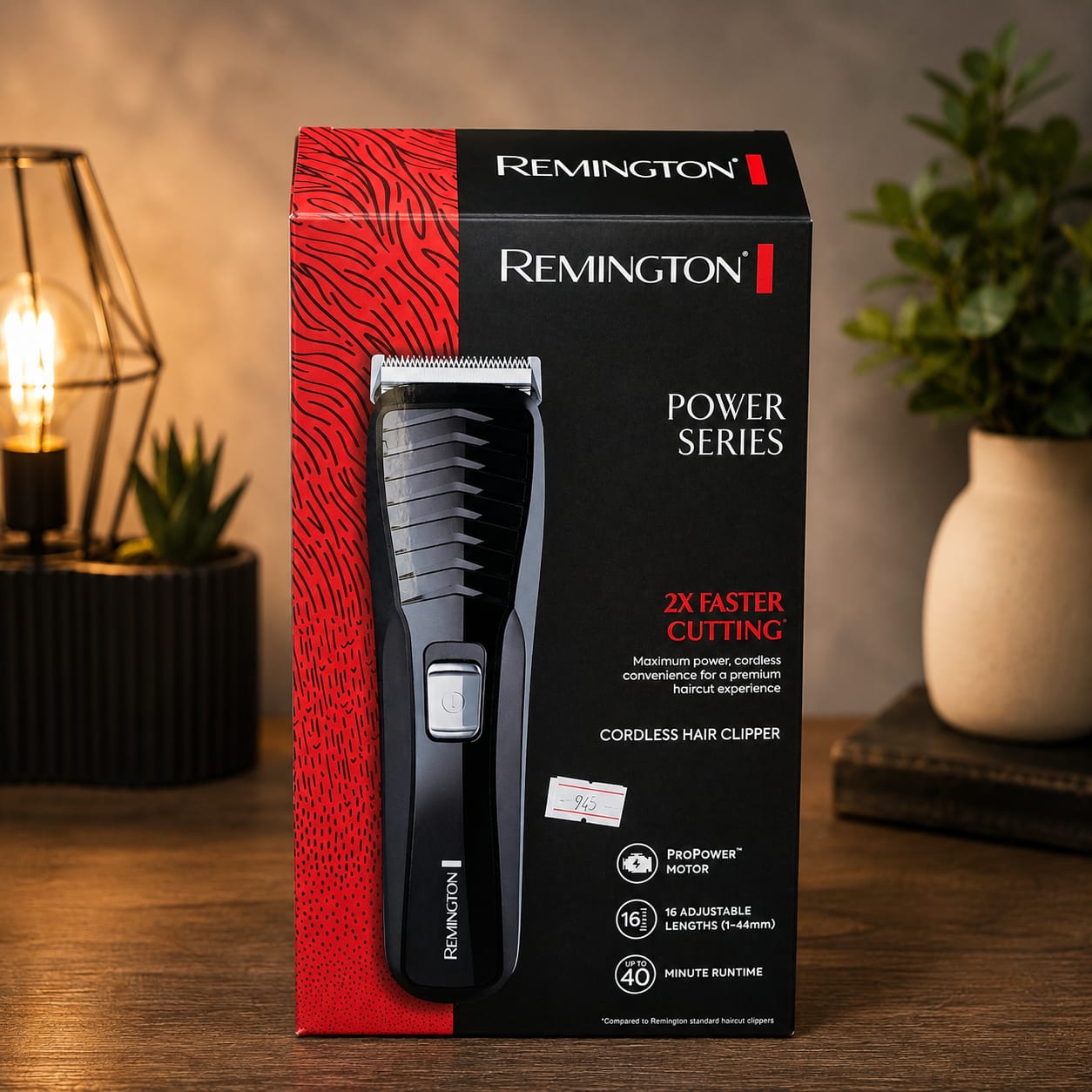 Caja de máquina cortadora de cabello inalámbrica Remington Power Series HC7130 en color negro y rojo. El empaque muestra la cortadora al frente e indica motor ProPower, 16 longitudes ajustables de 1 a 44 mm y hasta 40 minutos de autonomía. La caja está colocada sobre una mesa de madera con decoración de lámpara y plantas al fondo.